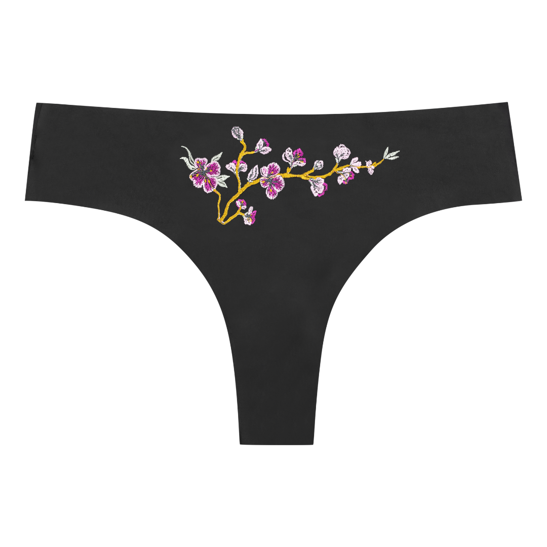 soft seamless tap shoe black thong underwear with an embroidered floral pattern in contrasting colors against white background.
