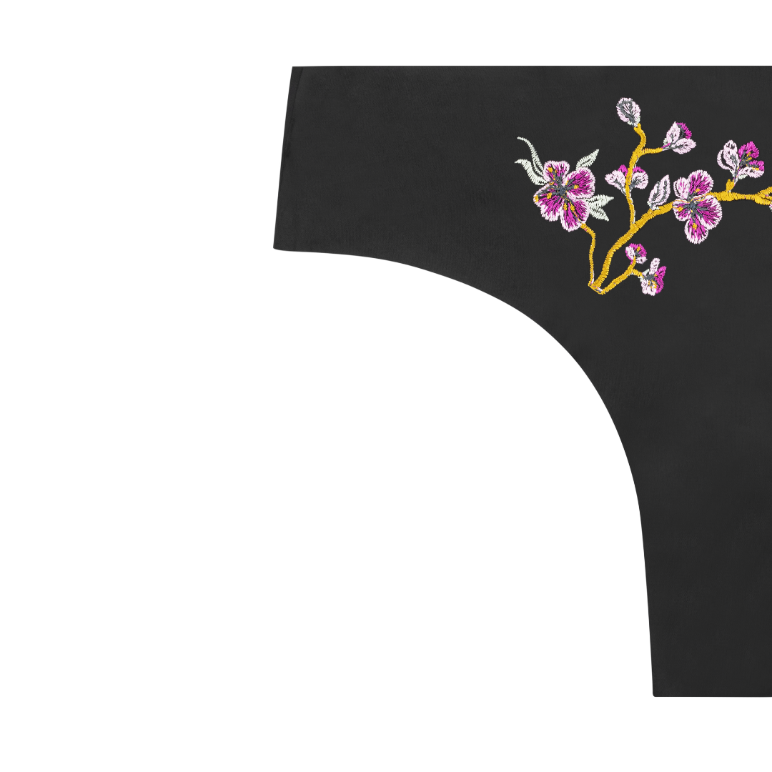 soft seamless tap shoe black thong underwear with an embroidered floral pattern in contrasting colors against white background.