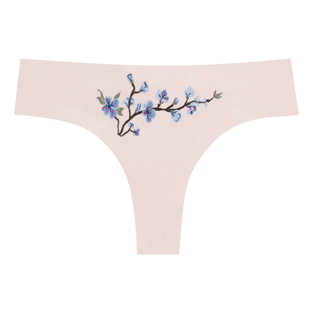 A soft seamless rose quartz thong underwear with an embroidered floral pattern in contrasting colors.