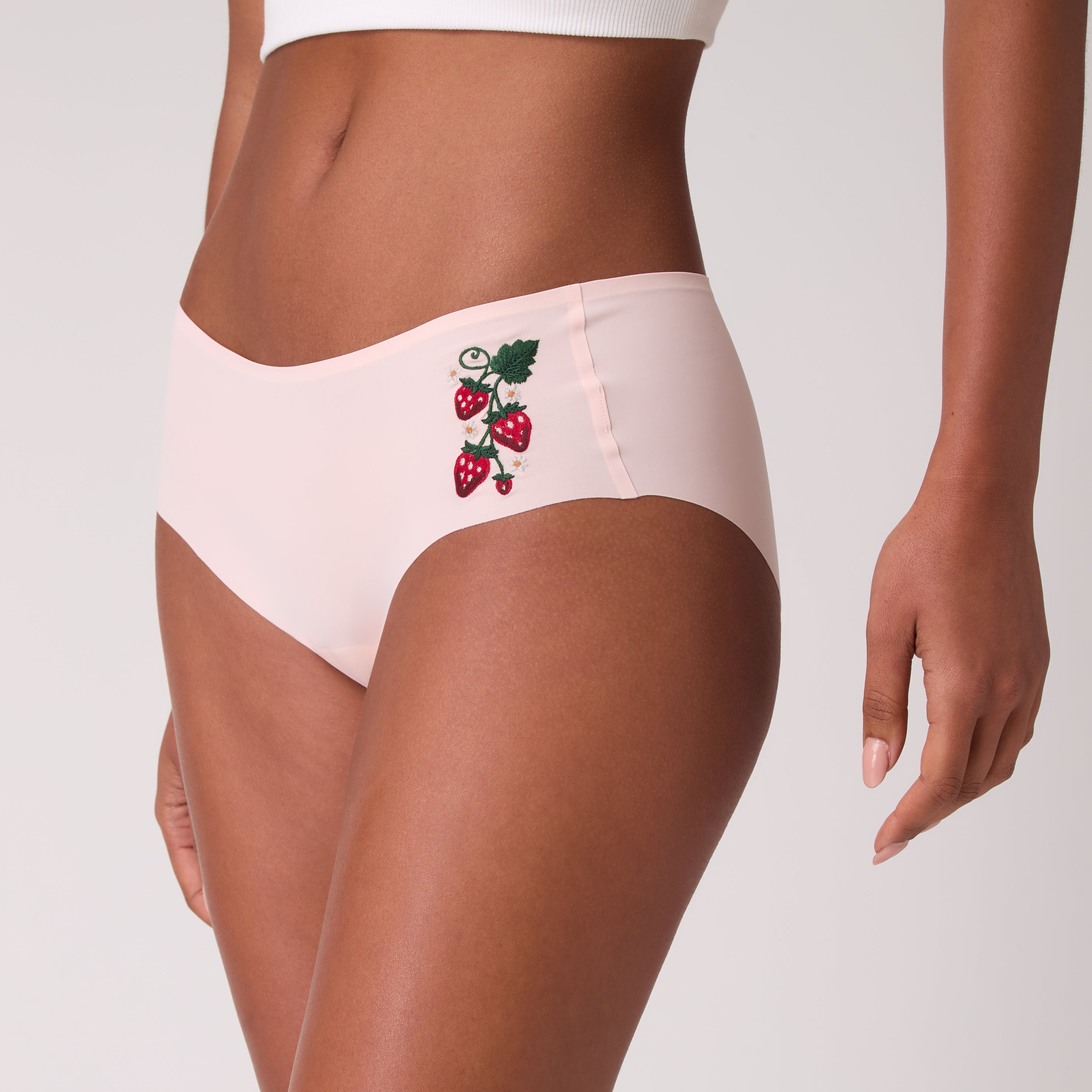 Model wearing Uwila Warrior Soft Seamless Rose Quartz Briefs with Wild Strawberry embroidery.