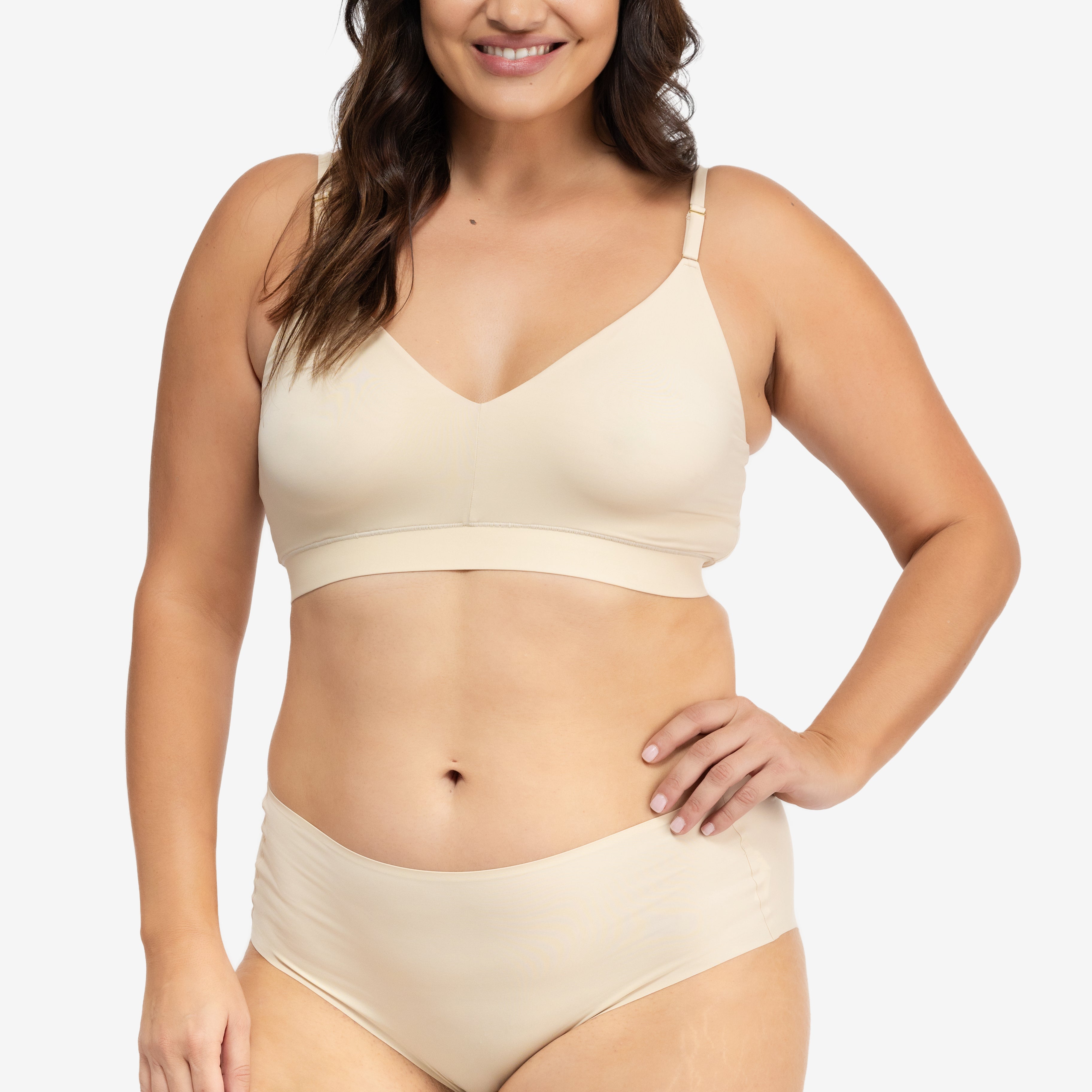 A woman wearing a smoke grey, underwire-free soft bra with adjustable straps and removable cup inserts on white background.