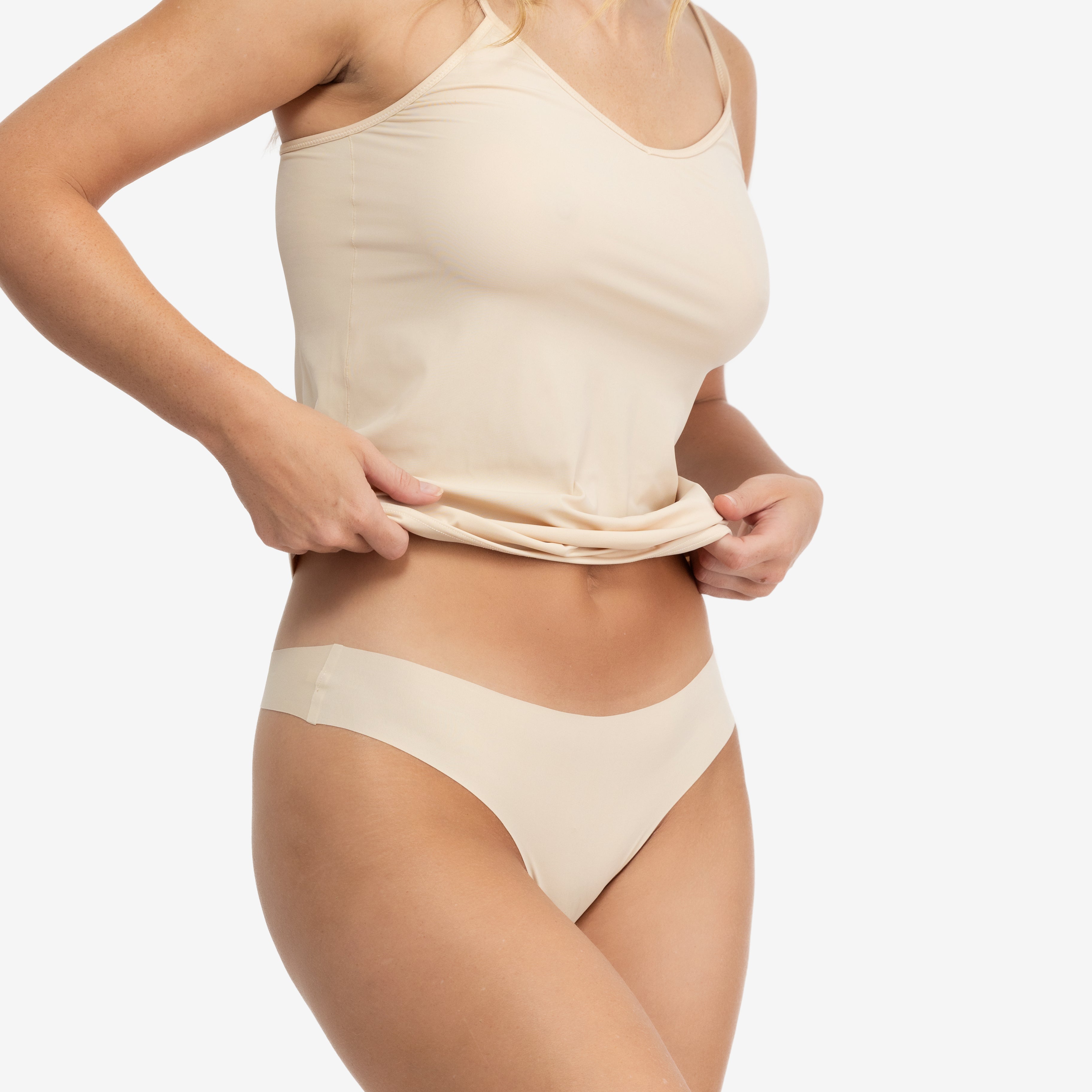 A woman wearing a smoke grey soft seamless thong underwear on white background.