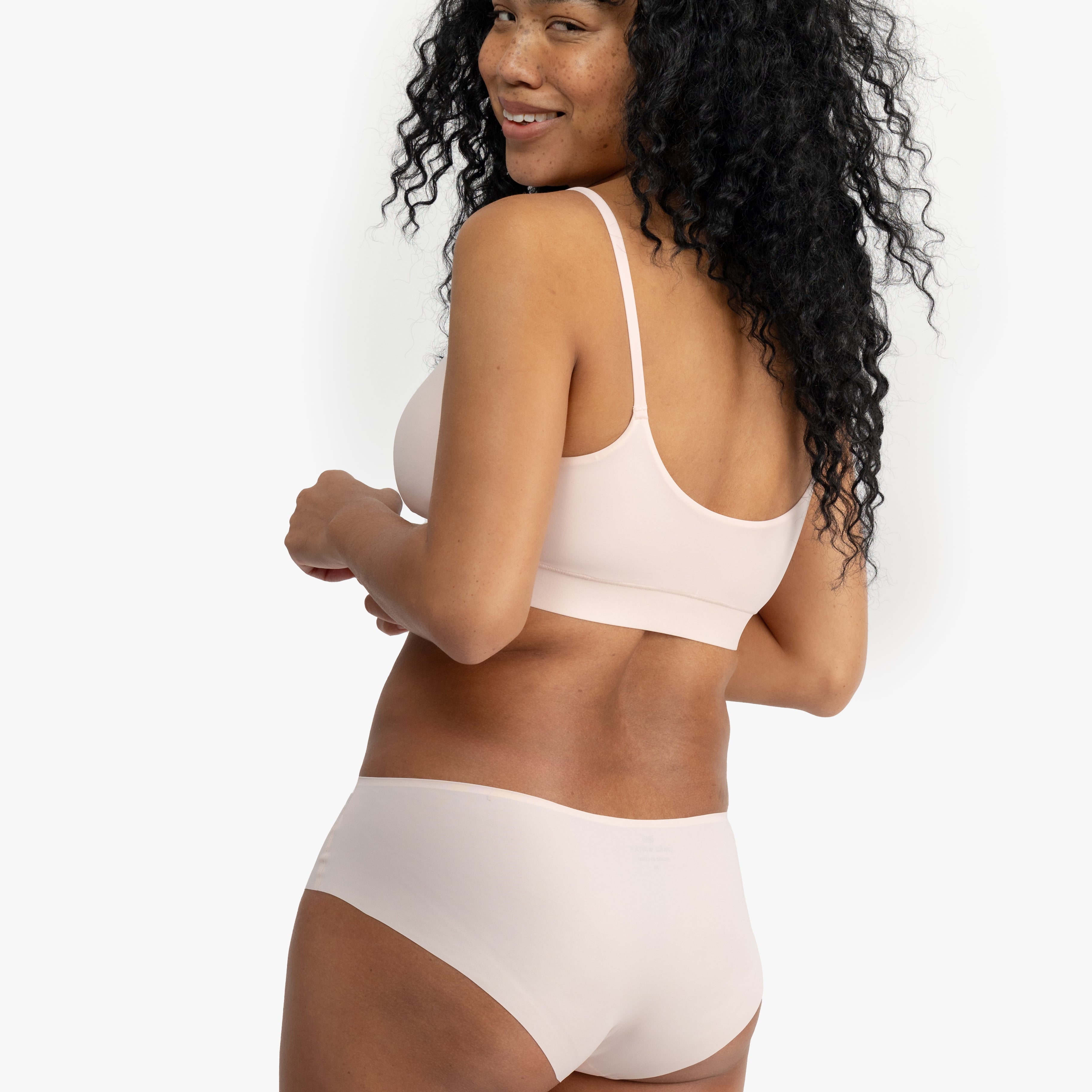 Model wearing Uwila Warrior Better Briefs Soft Bra in Rose Quartz on White Background