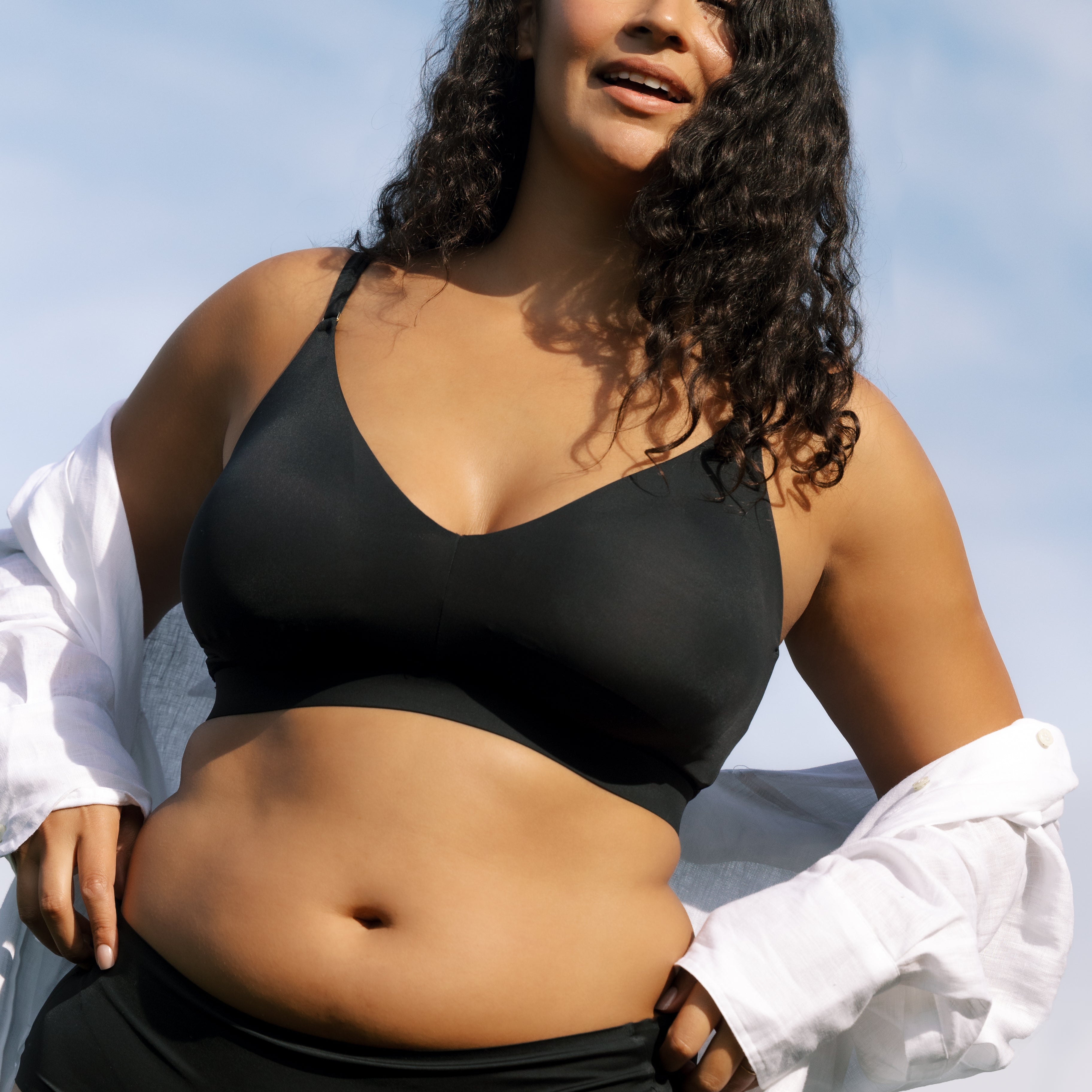 Model wearing Uwila Warrior Better Briefs Soft Bra in Tap Shoe Black on Blue Background