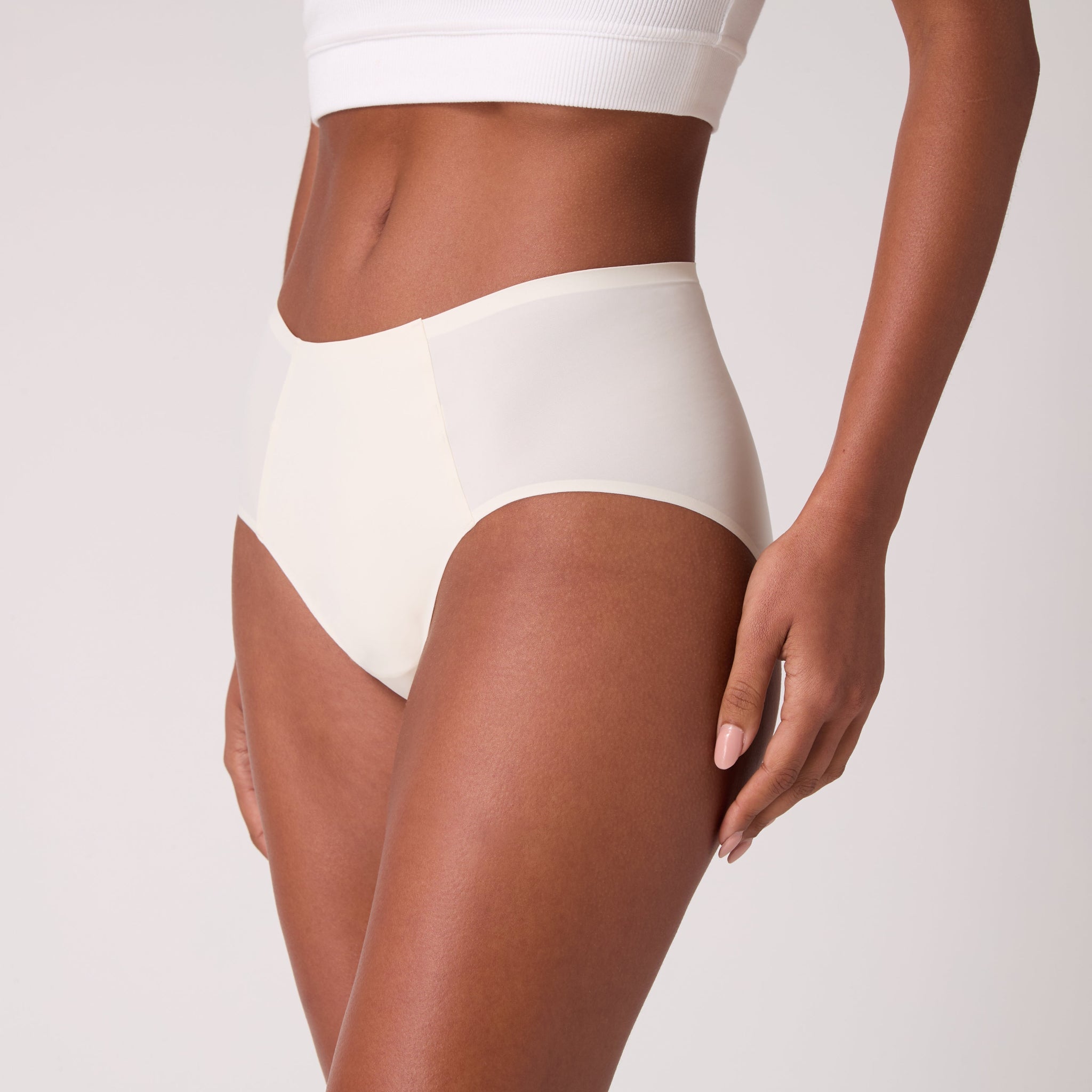 Model wearing Soft Seamless High Waisted Brief in Winter White on white background.