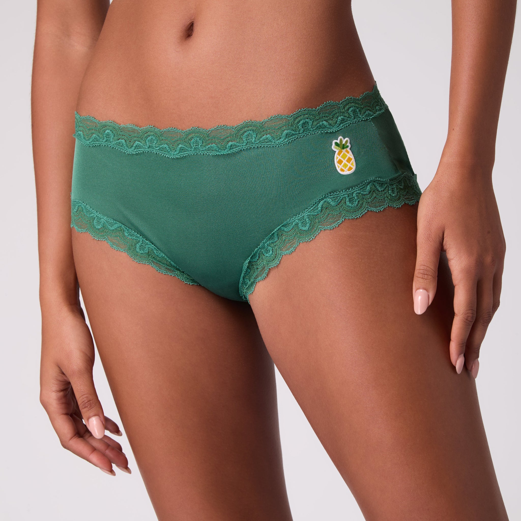 Model wearing Uwila Warrior Smoke Pine Soft Silk Briefs with Embroidered pineapple patch.