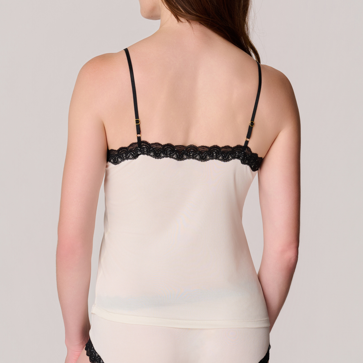 Back view of a model wearing Soft Silk Winter White Camisole and Briefs with Contrasting Tap Shoe Black Lace on a white background.