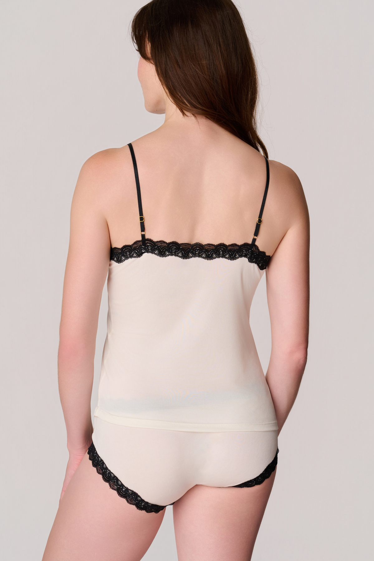 Back view of a model wearing Soft Silk Winter White Camisole and Briefs with Contrasting Tap Shoe Black Lace on a white background.