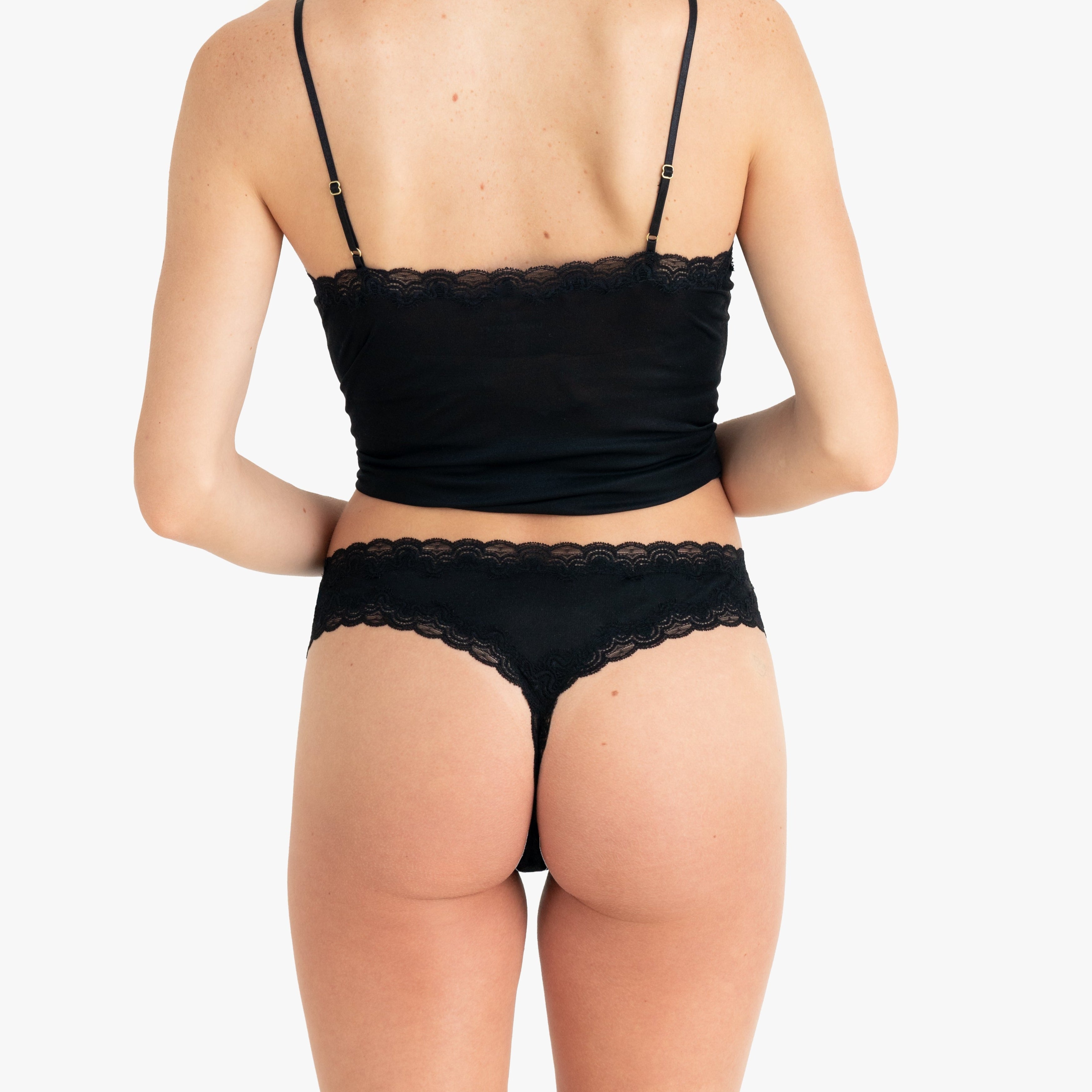 Model wearing Uwila Warrior Soft Silks Thong Underwear in Tap Shoe Black on White Background