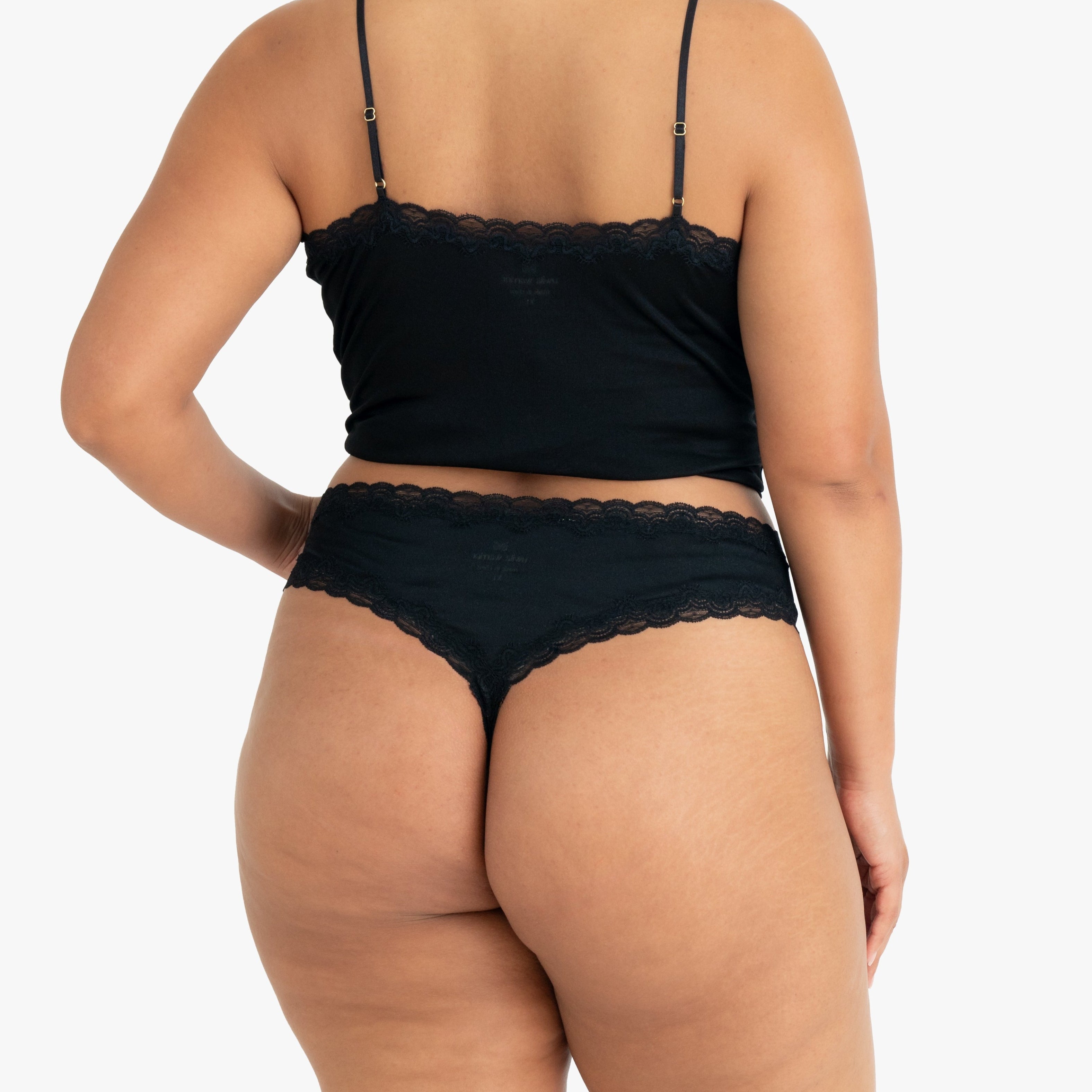Model wearing Uwila Warrior Soft Silks Thong Underwear in Tap Shoe Black on White Background