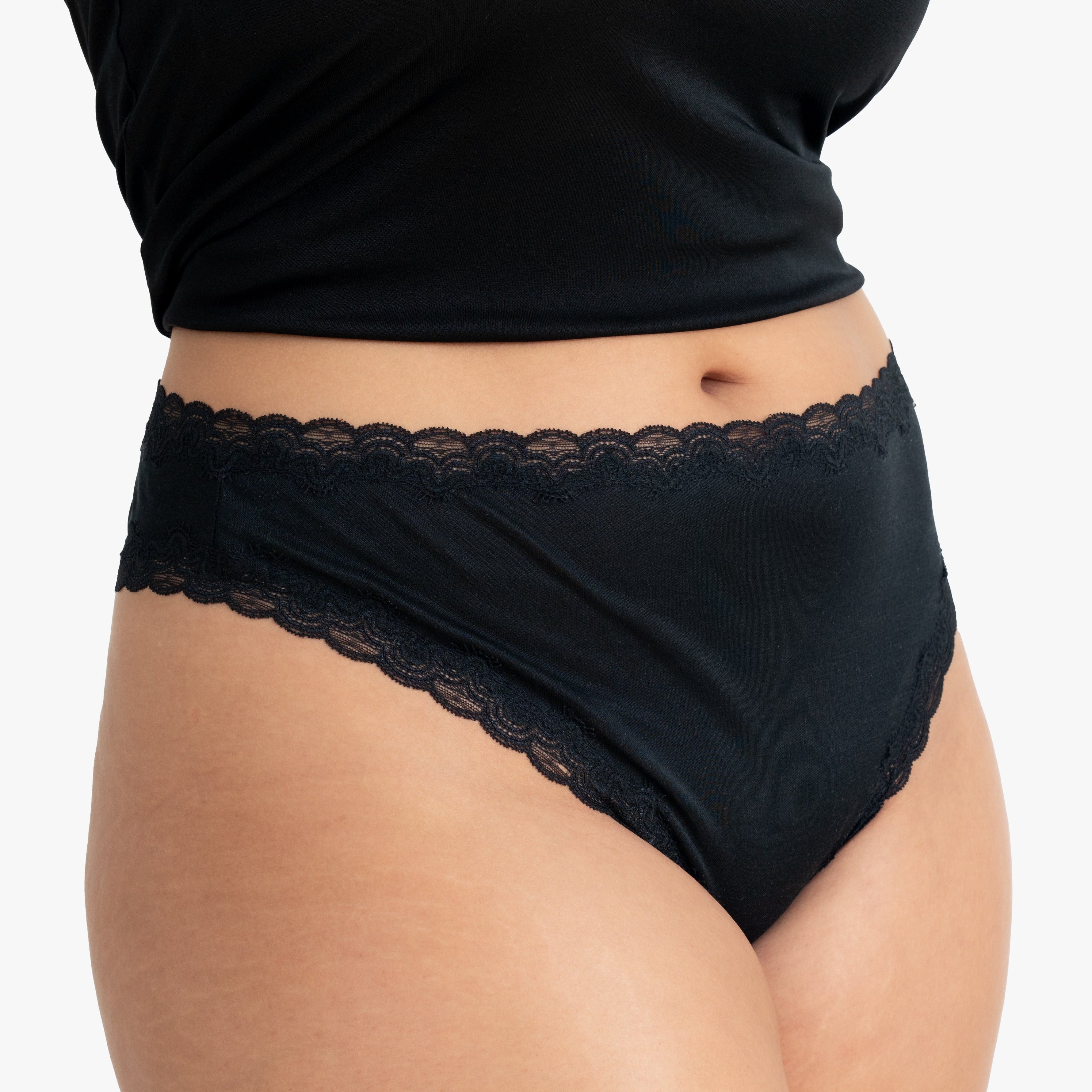 Model wearing Uwila Warrior Soft Silks Thong Underwear in Tap Shoe Black on White Background