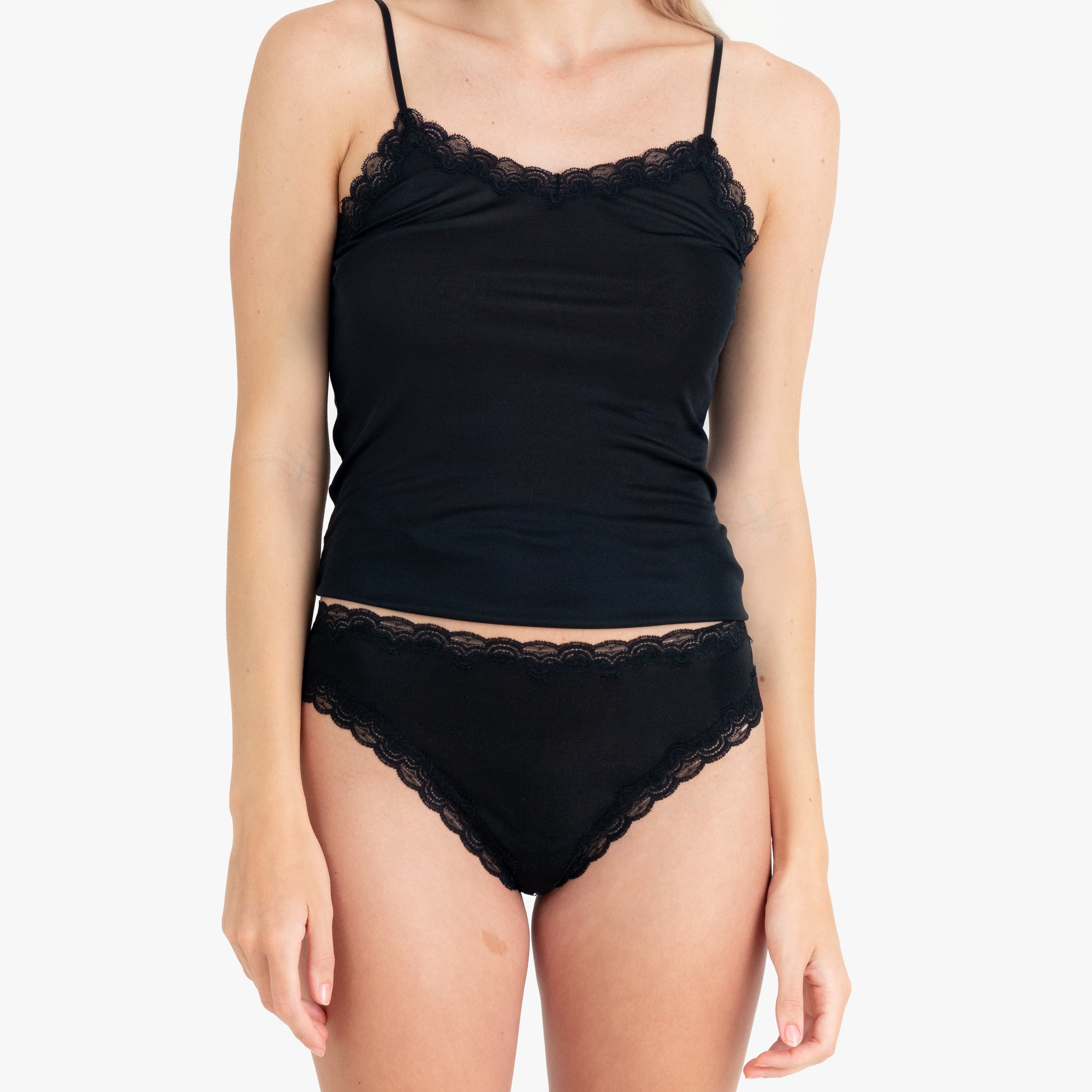 Model wearing Uwila Warrior Soft Silks Thong Underwear in Tap Shoe Black on White Background