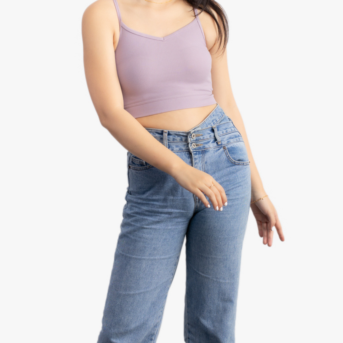 A woman wearing a nirvana bralette with thin straps and a ribbed texture and jeans on white background.