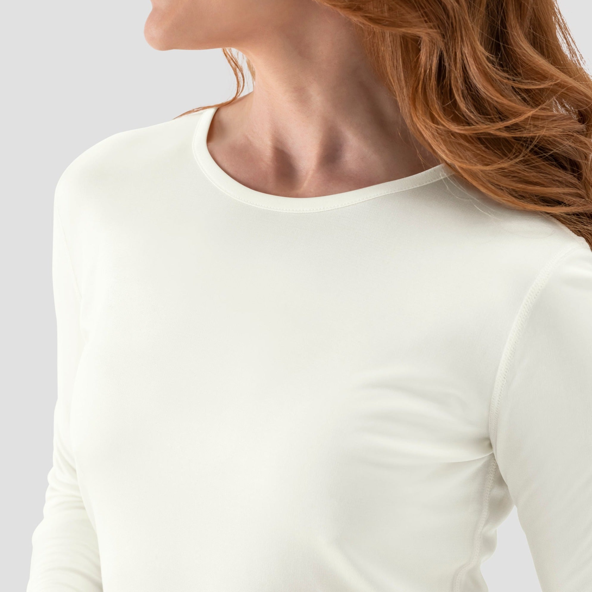 A model wearing a long-sleeve Cream base layer T-shirt by Uwila Warrior, shown in against a white background.