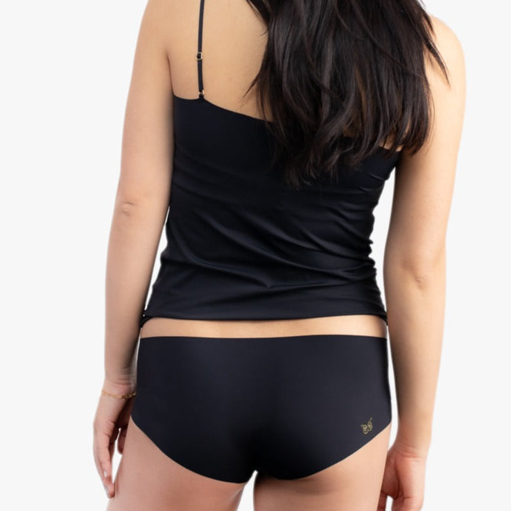 A woman wearing a tap shoe black soft seamless underwear briefs and cami set with lace details.