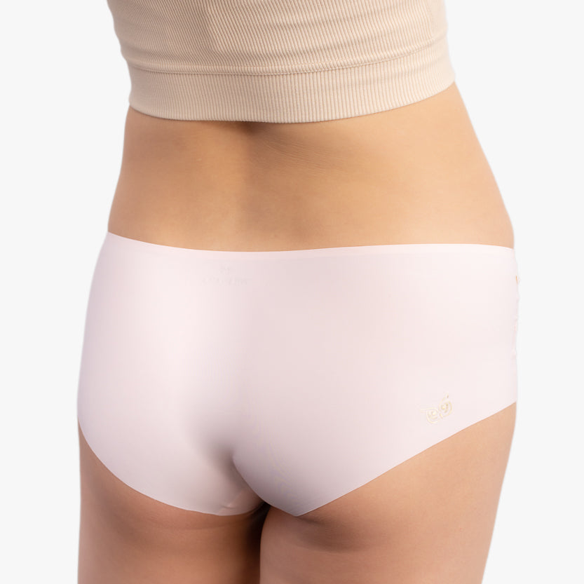 A pair of rose quartz soft seamless briefs with lace detailing white background.