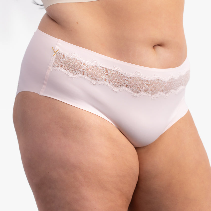 A pair of rose quartz soft seamless briefs with lace detailing white background.
