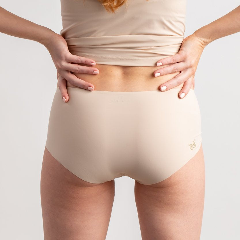 A woman wearing a smoke grey seamless underwear briefs and cami set with lace details.