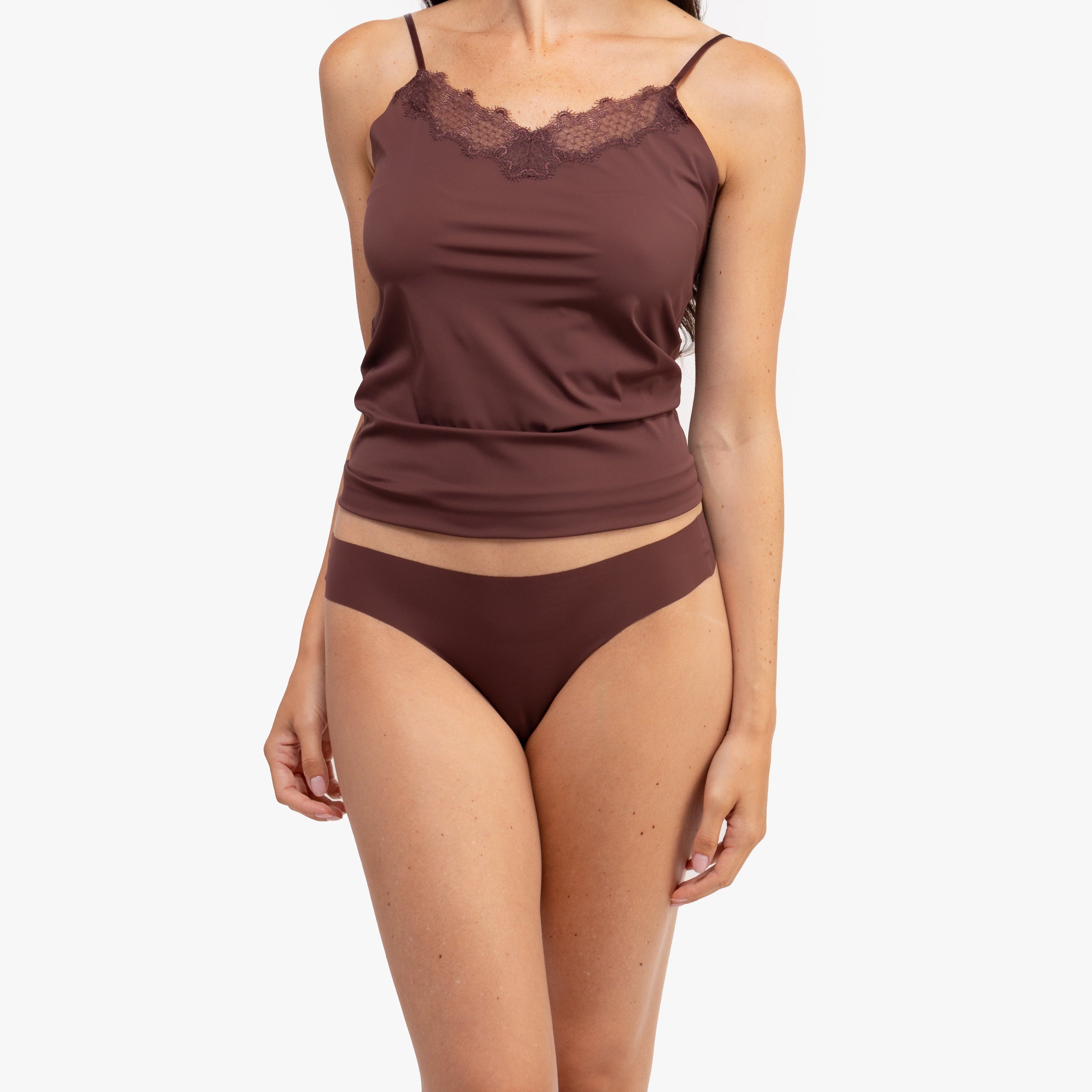 A woman wearing a chocolate soft seamless thong underwear on white background.
