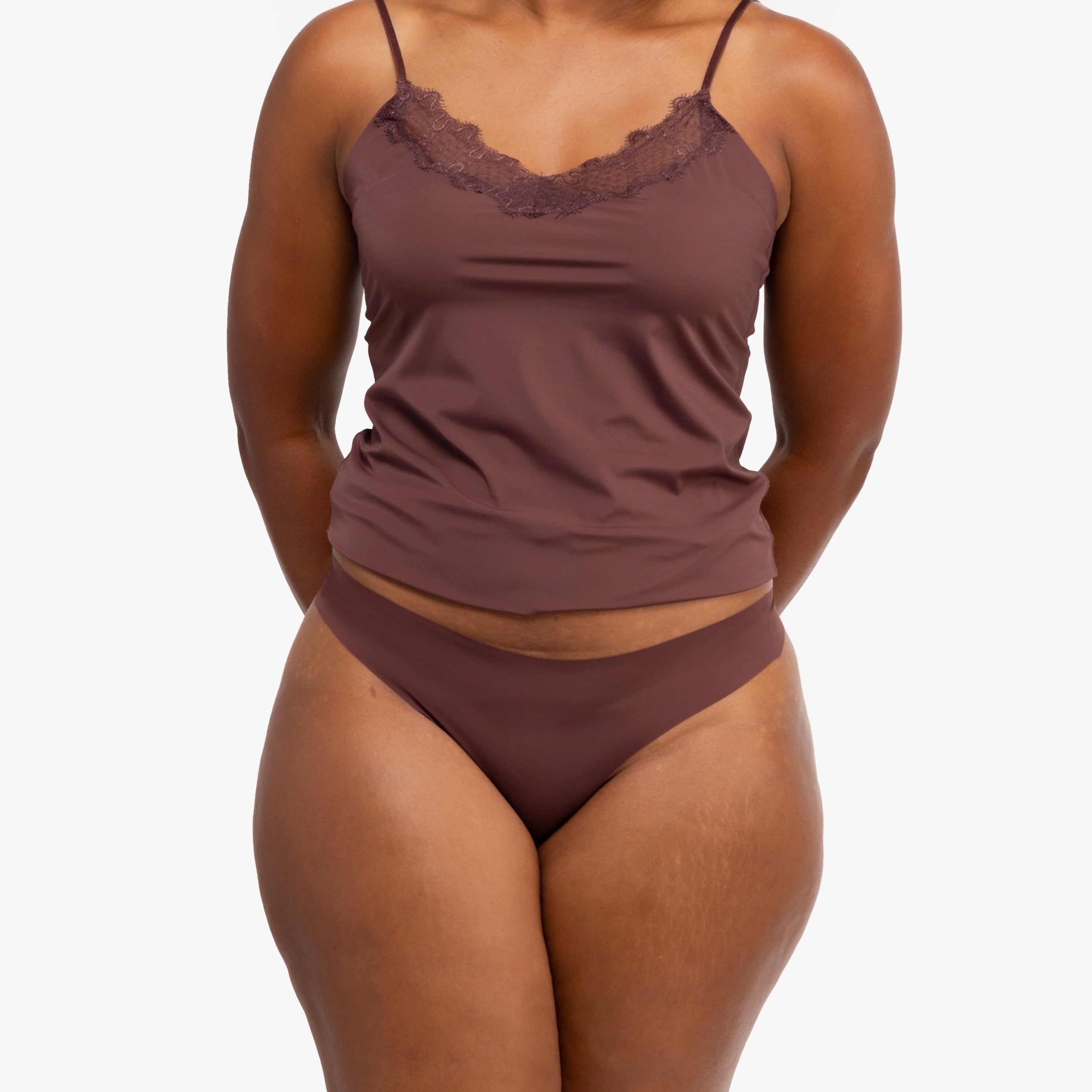 A woman wearing a chocolate soft seamless thong underwear on white background.