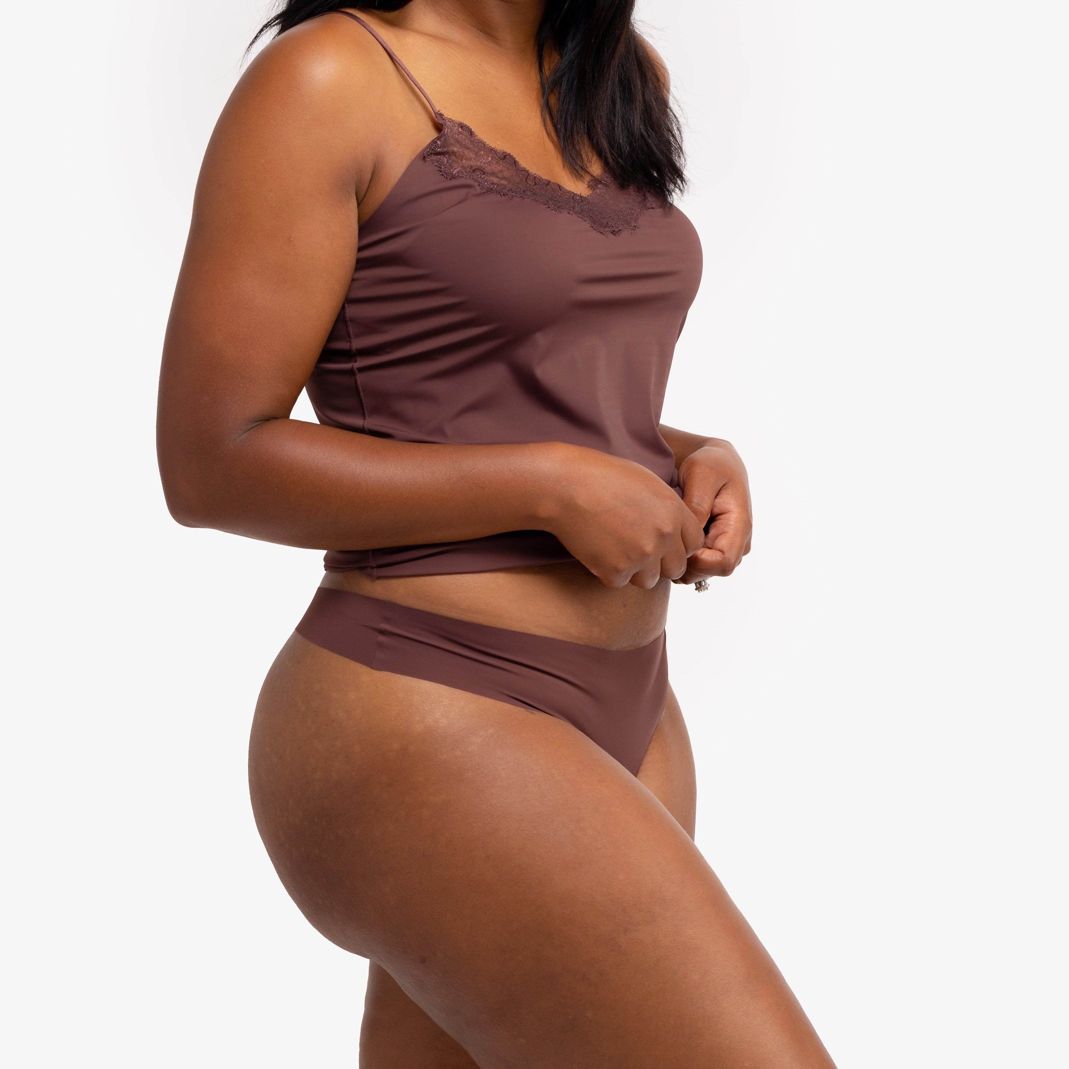 A woman wearing a chocolate soft seamless thong underwear on white background.
