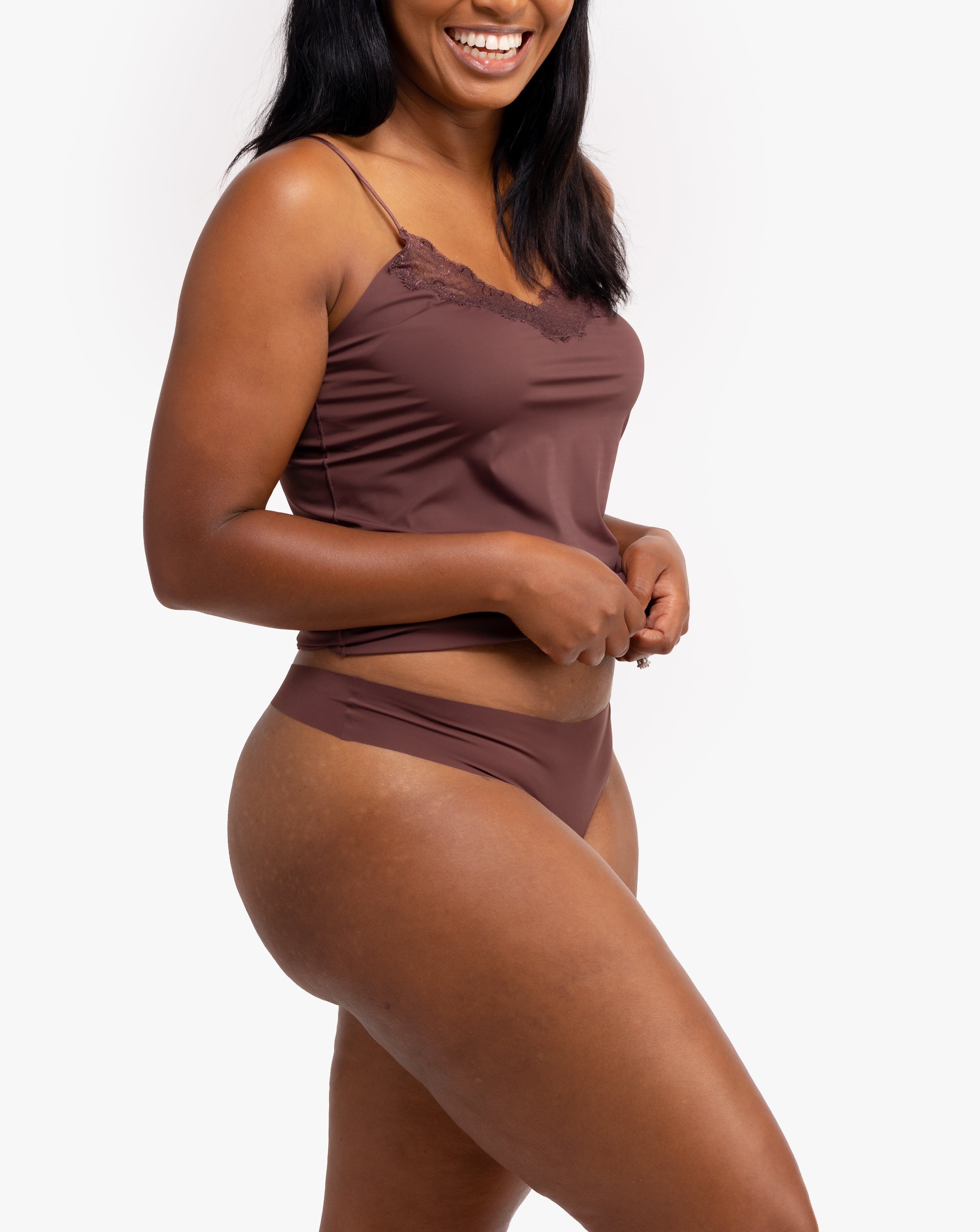 A woman wearing a chocolate soft seamless thong underwear on white background.