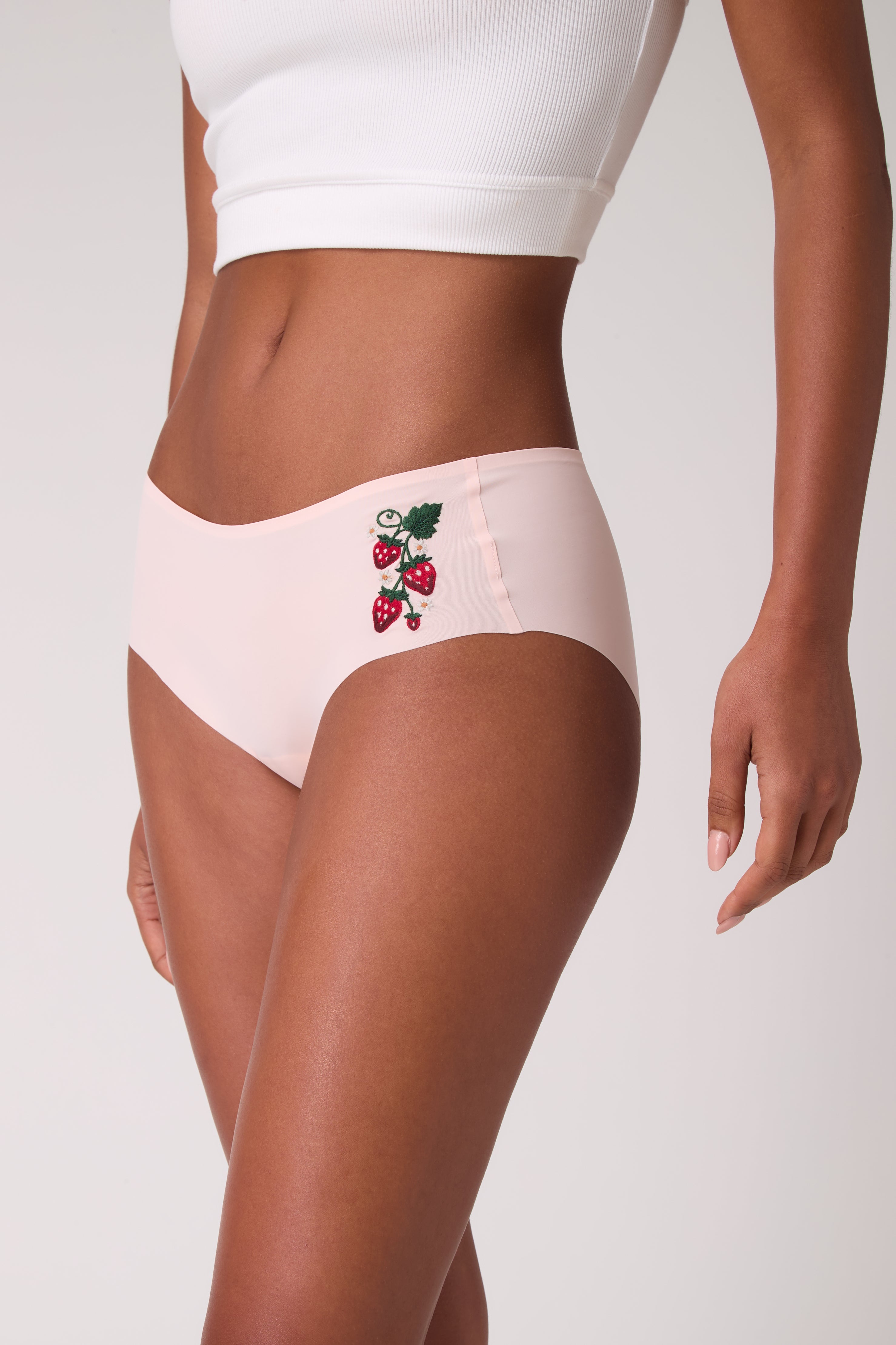 Model wearing Uwila Warrior Soft Seamless Rose Quartz Briefs with Wild Strawberry embroidery. 