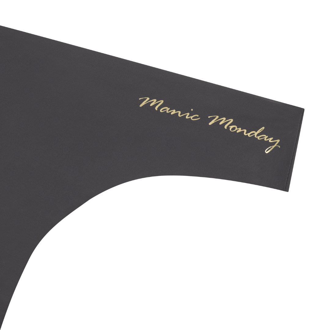 A shale soft seamless thong with 'Manic Monday' written in gold on the front.
