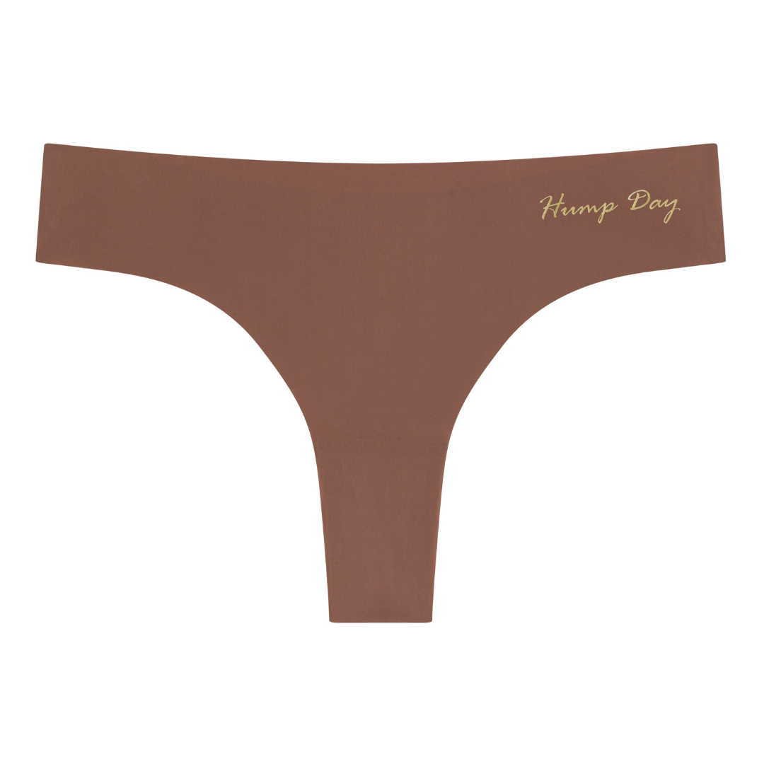 A toffee soft seamless thong with 'Hump Day' written in gold on the front.