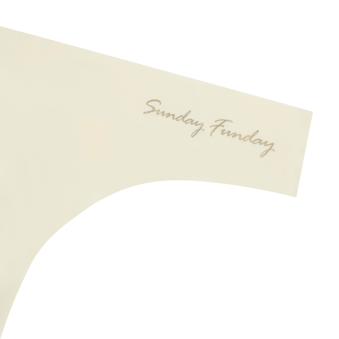 A Winter White soft seamless thong with 'Sunday Funday' written in gold on the front.