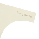 A Winter White soft seamless thong with 'Sunday Funday' written in gold on the front.
