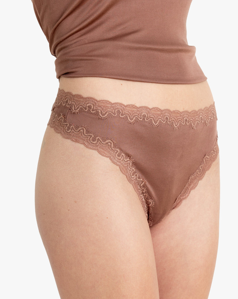 Model wearing Uwila Warrior Soft Silks Thong Underwear in Toffee on White Background