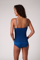 Model wearing Estate Blue Soft Silk camisole on white background. 