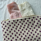 Polka dot canvas bag with rose quart and winter white soft seamless lace underwear on white background.