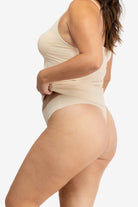 A woman wearing a smoke grey soft seamless thong underwear on white background.