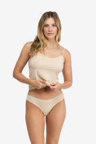 A woman wearing a smoke grey soft seamless thong underwear on white background.