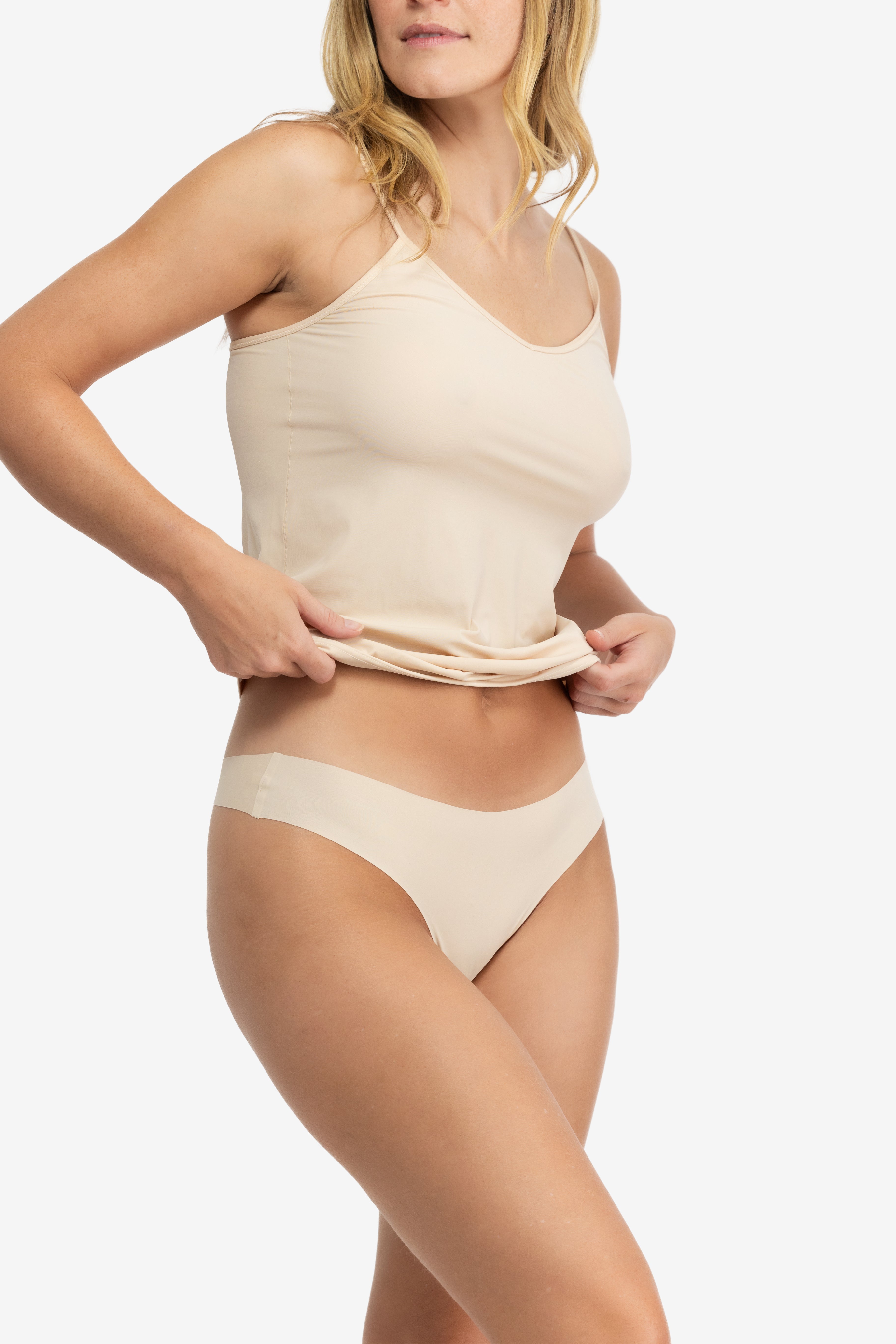 A woman wearing a smoke grey soft seamless thong underwear on white background.