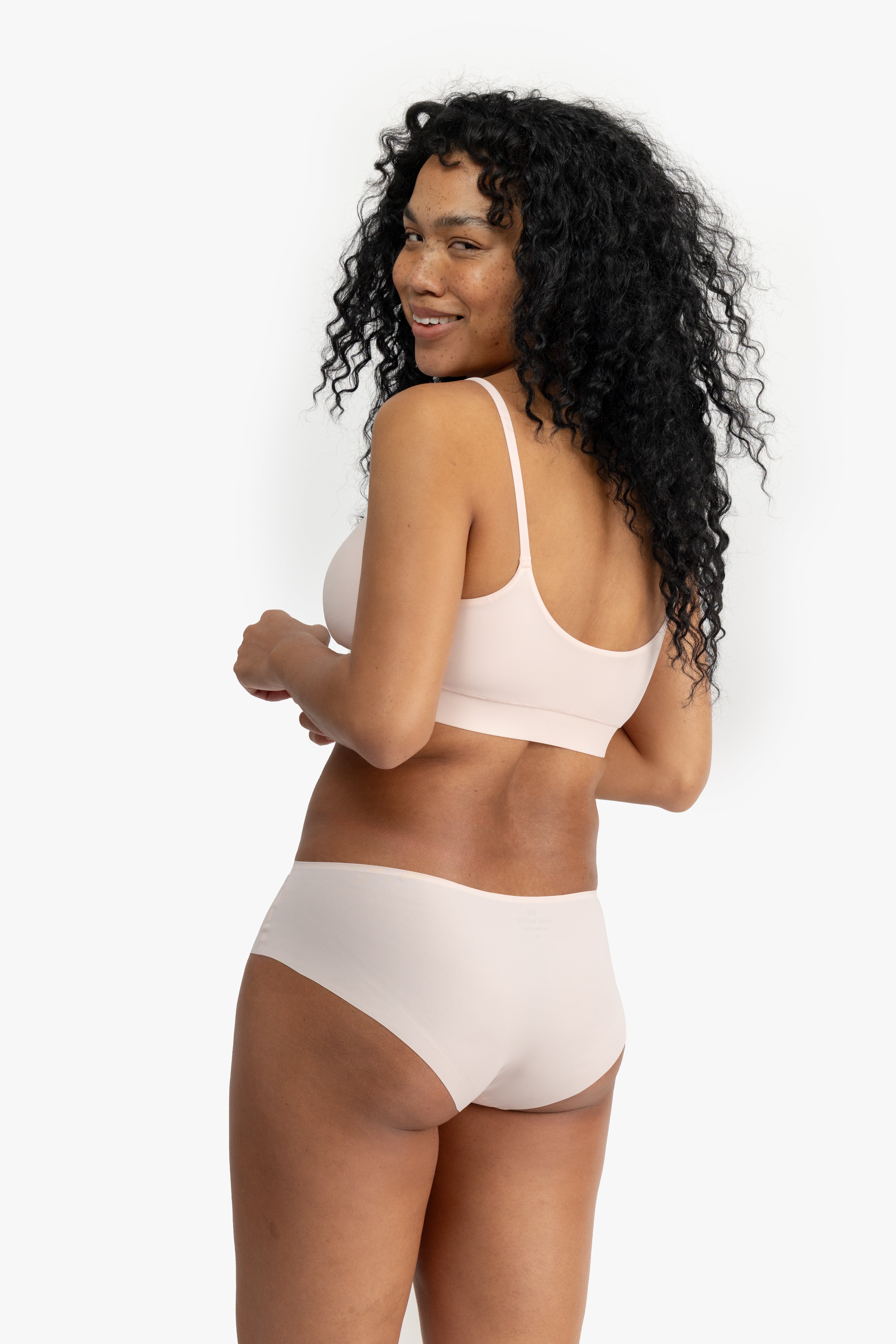 Model wearing Uwila Warrior Better Briefs Soft Bra in Rose Quartz on White Background