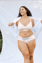 Model wearing Uwila Warrior Better Briefs Soft Bra in Rose Quartz on White Background