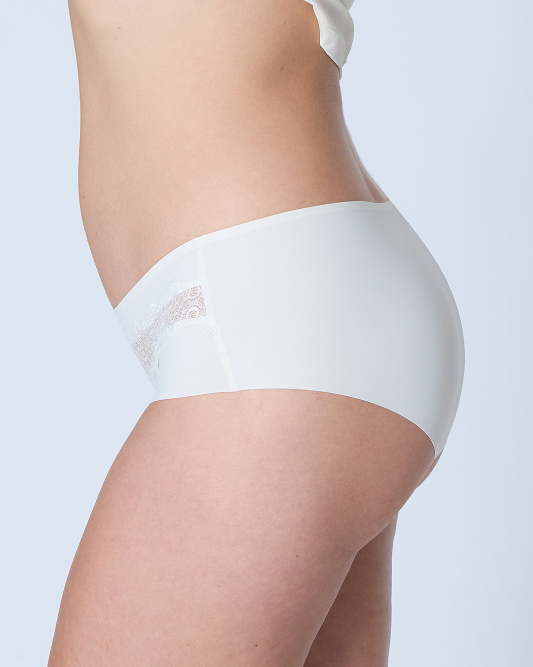 White underwear with lace trim on a plain background