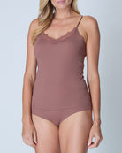 Woman wearing a toffee soft seamless  lace-trimmed camisole against a light gray background
