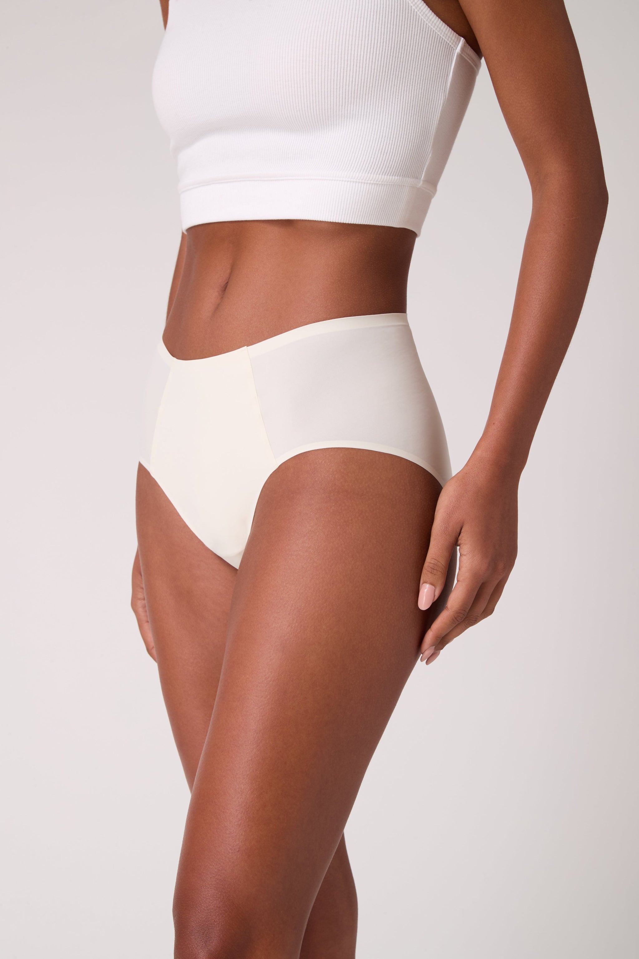 Model wearing Soft Seamless High Waisted Brief in Winter White on white background.