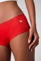 Model wearing Uwila Warrior Fiery Red Soft Silk briefs with orange patch. 