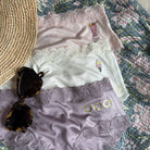 Uwila Warrior Getaway Bundle with sunglasses and hat on floral background.