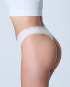 Model wearing Uwila Warrior Soft Silks Thong Underwear in Winter White on White Background