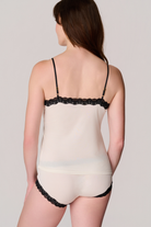 Back view of a model wearing Soft Silk Winter White Camisole and Briefs with Contrasting Tap Shoe Black Lace on a white background.