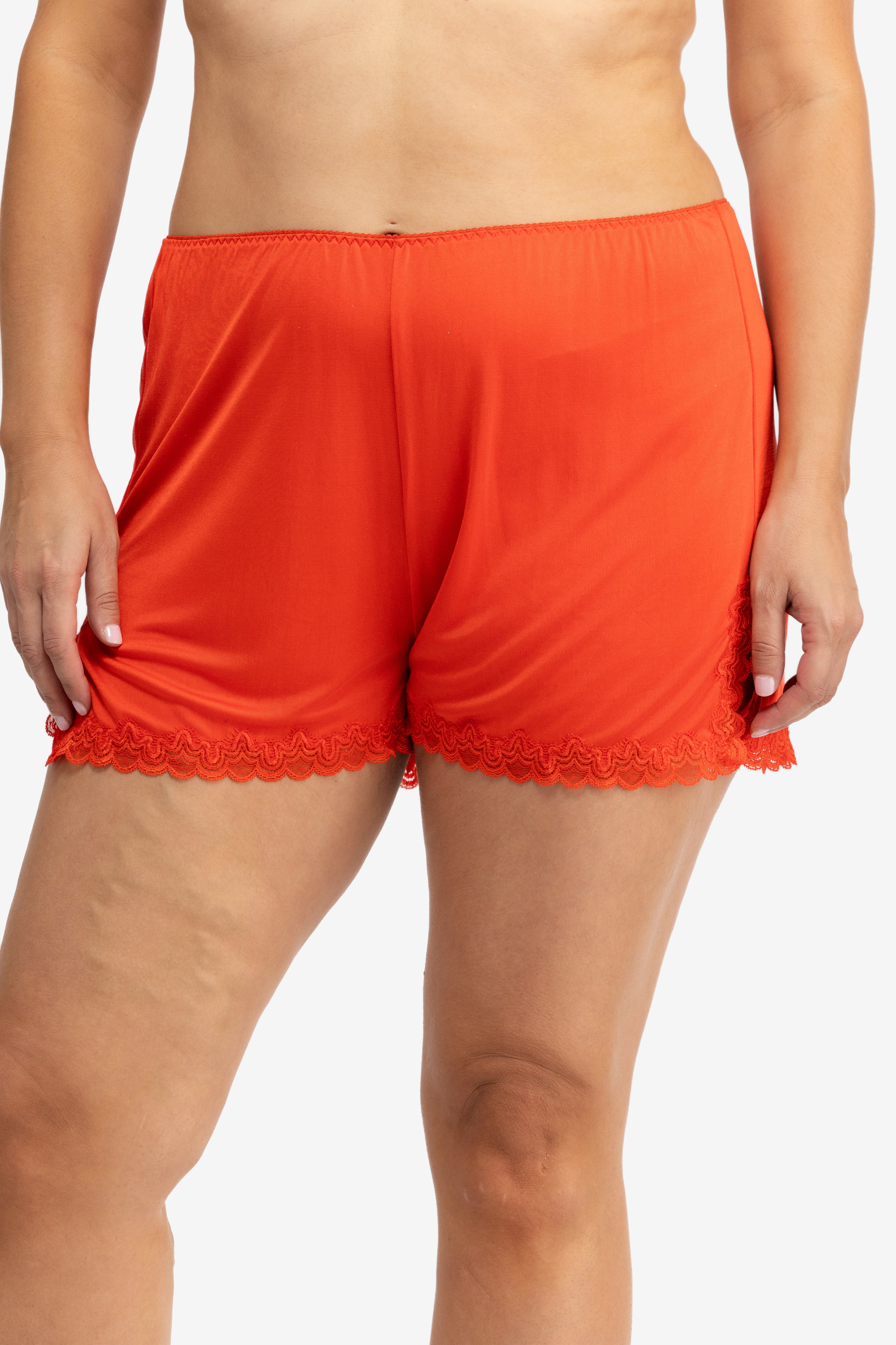 Model wearing Uwila Warrior Soft Silk Sleep Short in Fiery Red on White Background