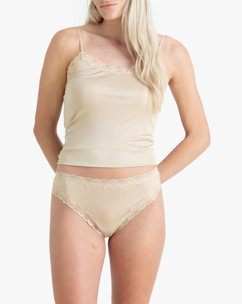 Model wearing Uwila Warrior Soft Silks Thong Underwear in Smoke Grey on White Background