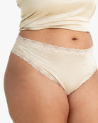 Model wearing Uwila Warrior Soft Silks Thong Underwear in Smoke Grey on White Background