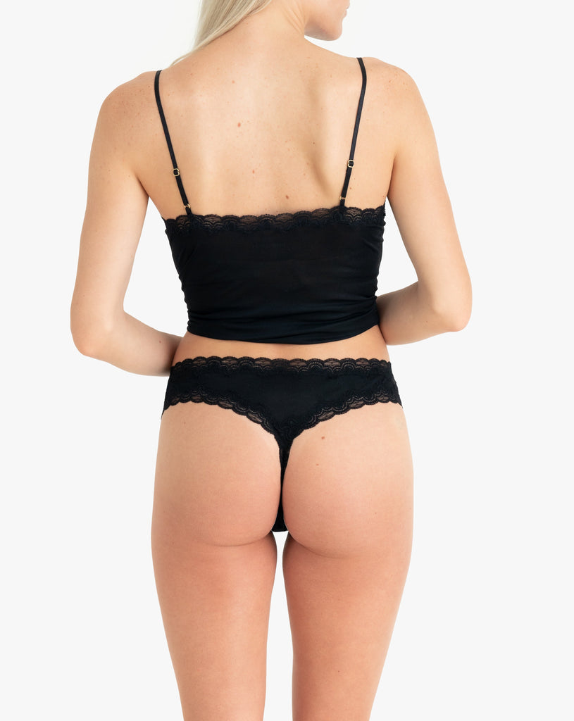 Model wearing Uwila Warrior Soft Silks Thong Underwear in Tap Shoe Black on White Background